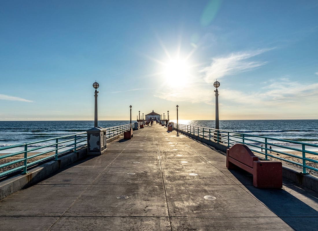 Contact - View of a Pier on the Beach at Sunset in California with a Blue Sky