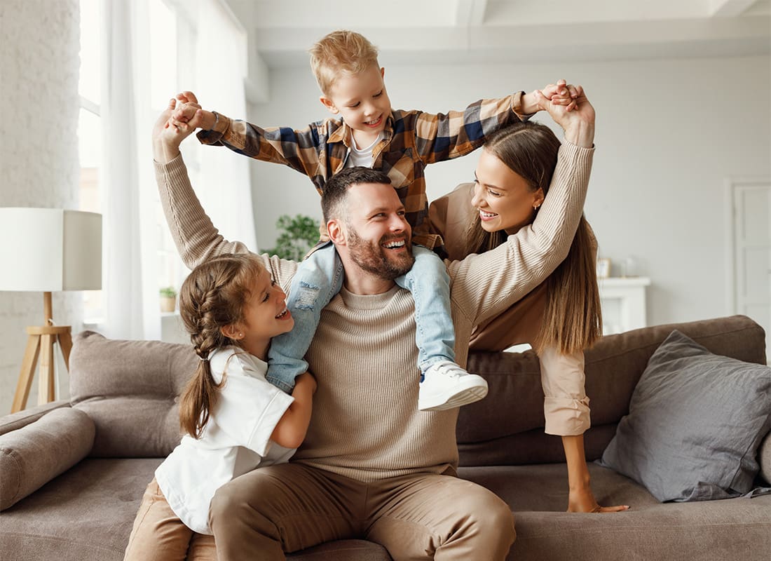 Personal Insurance - Portrait of a Cheerful Family with a Young Son and Daughter Spending Time Together at Home